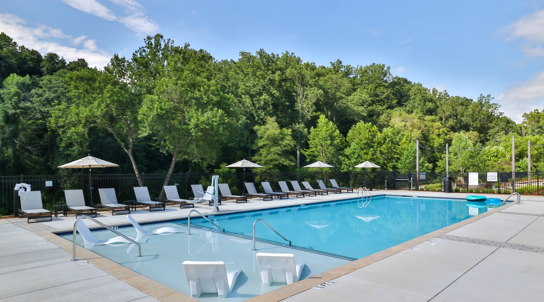 Resort Style Pool Resort-style pool with lounge chairs at The Hominy apartments in Candler, NC.